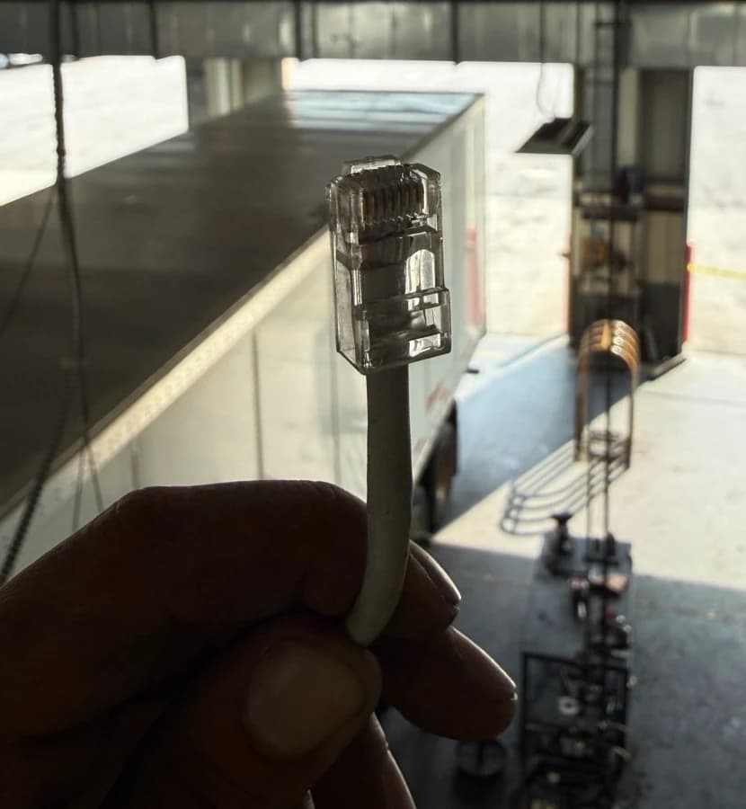 Joe holding an Ethernet connector during onsite cable preparation.