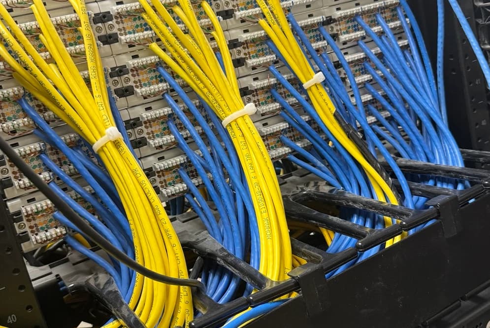 A cropped JODA field photograph showing Ethernet cable terminations and rack cable management.